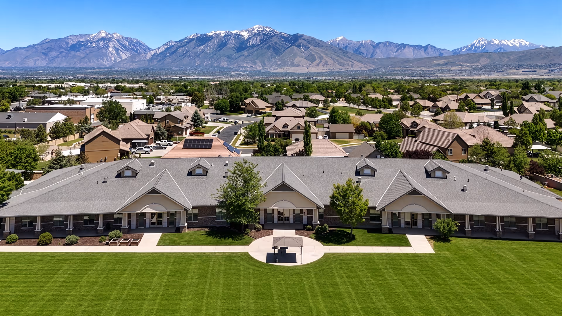 Front view of Rocky Mountain Care Riverton building with a green lawn and distant mountains.