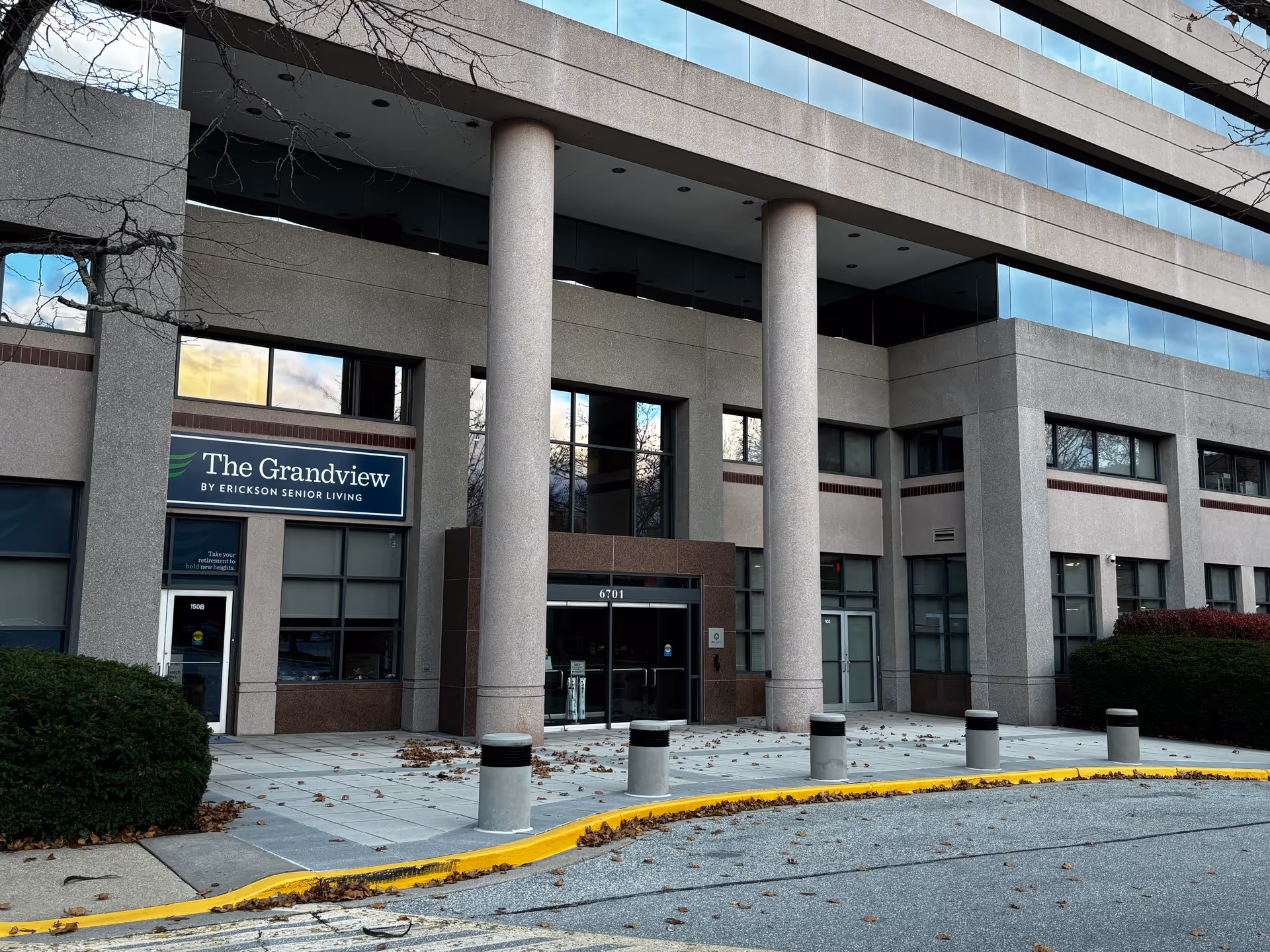 Front entrance of The Grandview senior living building with large columns, signage, and a curved driveway.