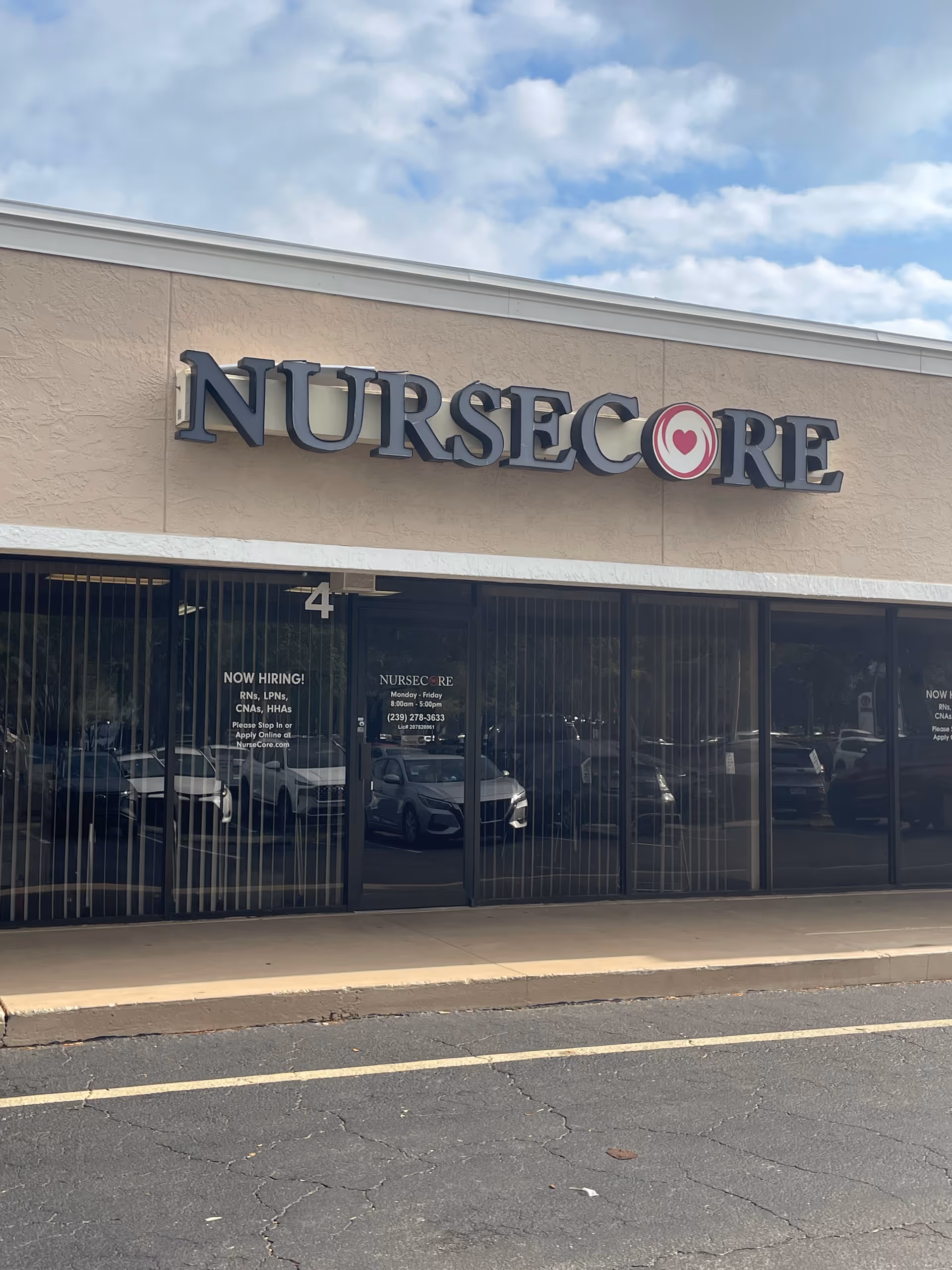 NurseCore building storefront with large sign and reflected parked cars