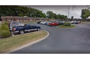Exterior view of Tyler Two facility with parked cars and curved driveway.