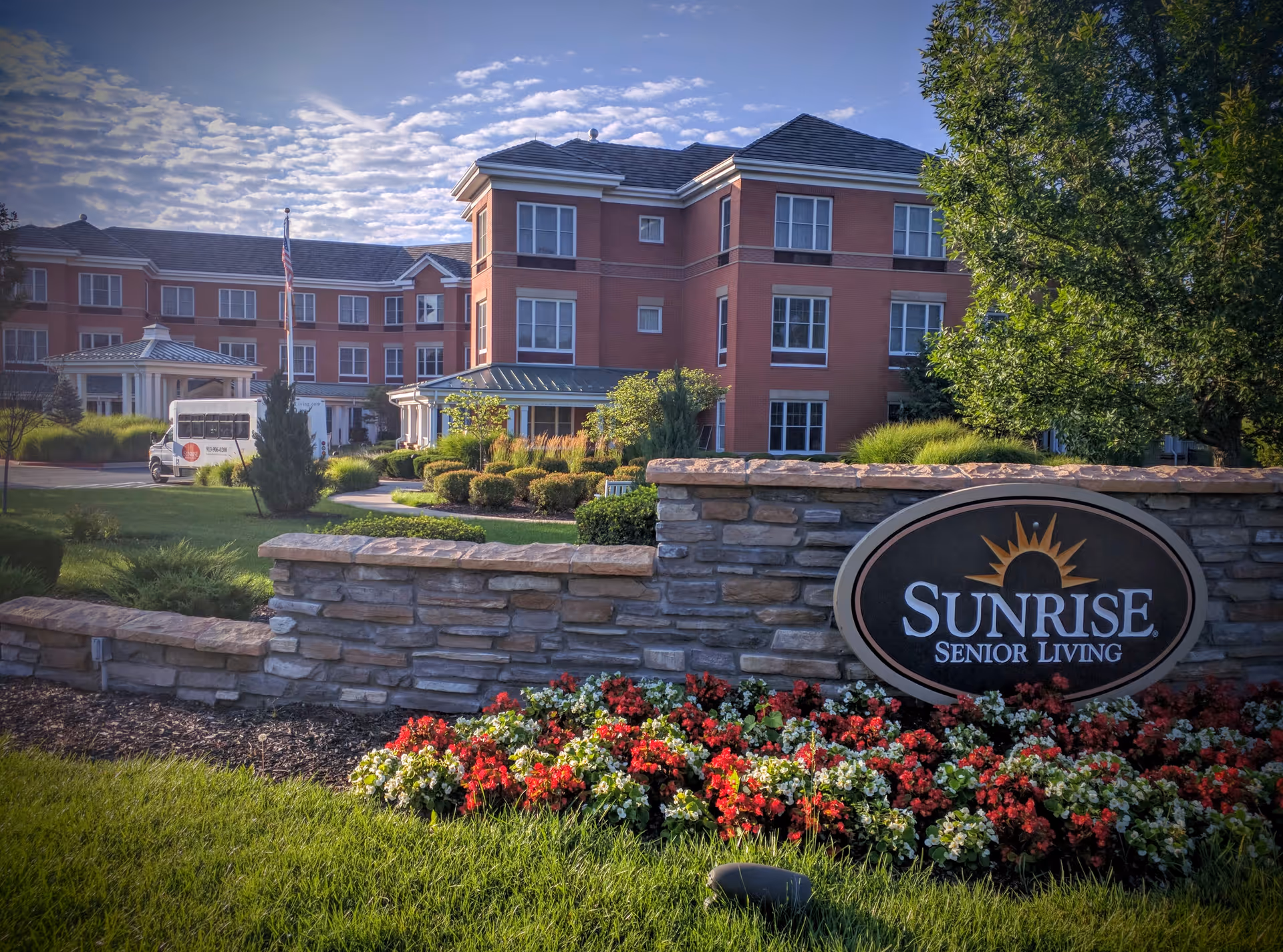 Front view of Sunrise Senior Living building with landscaped entrance and sign.