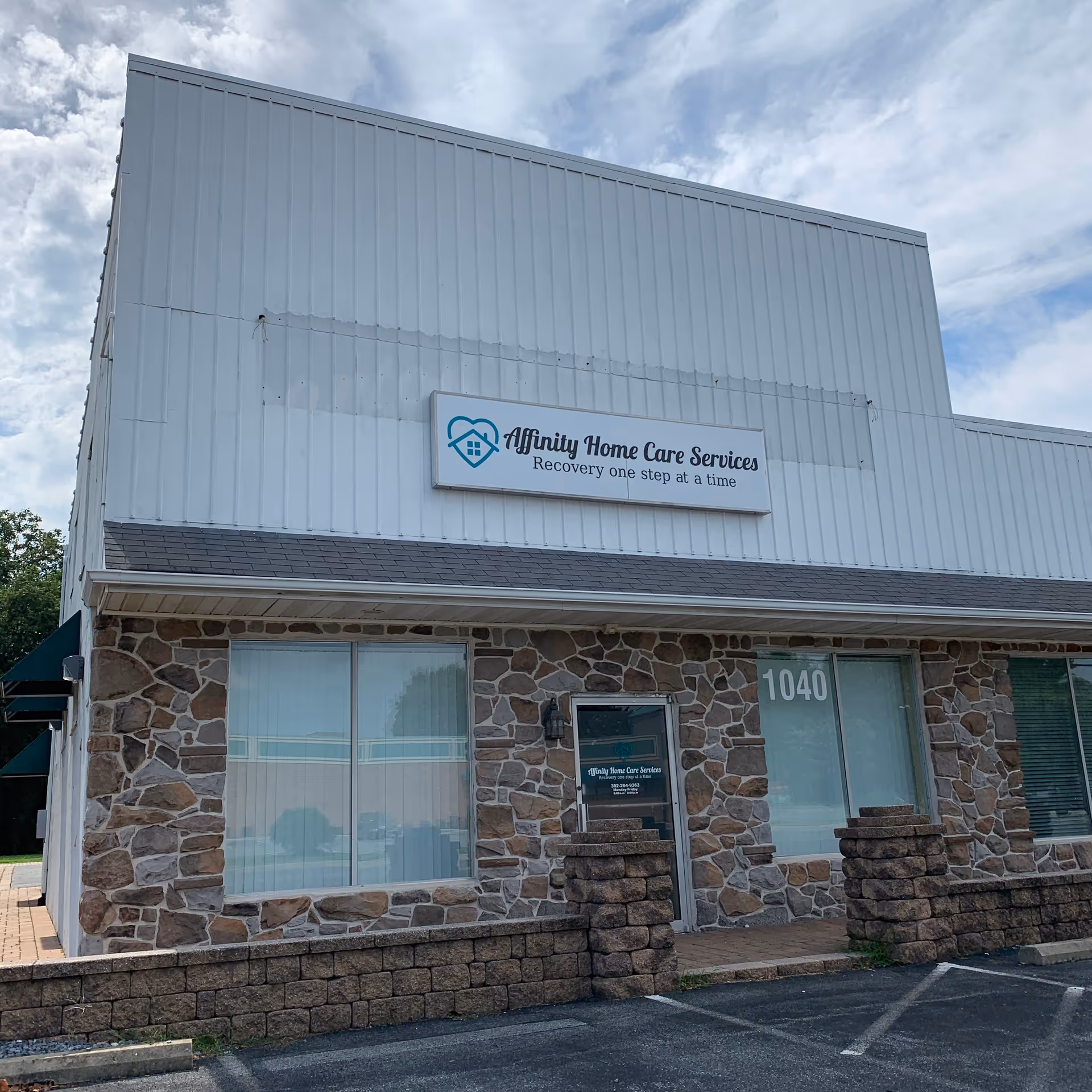 Exterior front of Affinity Home Care Services building with stone facade and sign.