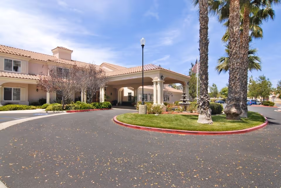 Exterior view of Brookdale Murrieta entrance with circular driveway and palm trees.