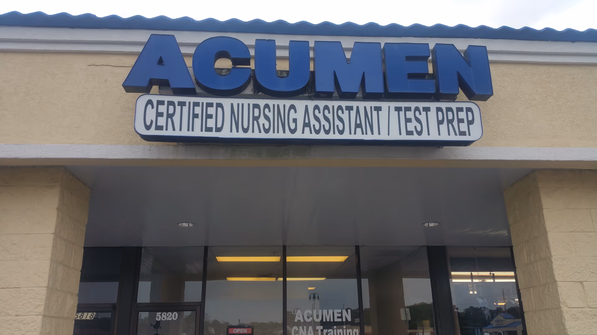 Front view of Acumen CNA Training Center entrance with large blue Acumen sign