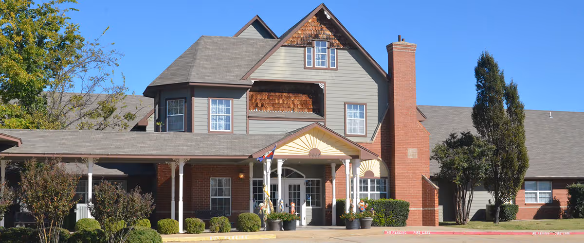 Front exterior view of Sand Plum Assisted Living Community with entrance and landscaping.
