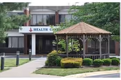 Exterior view of Serenity at Cedar Park Assisted Living building with a gazebo and landscaping.