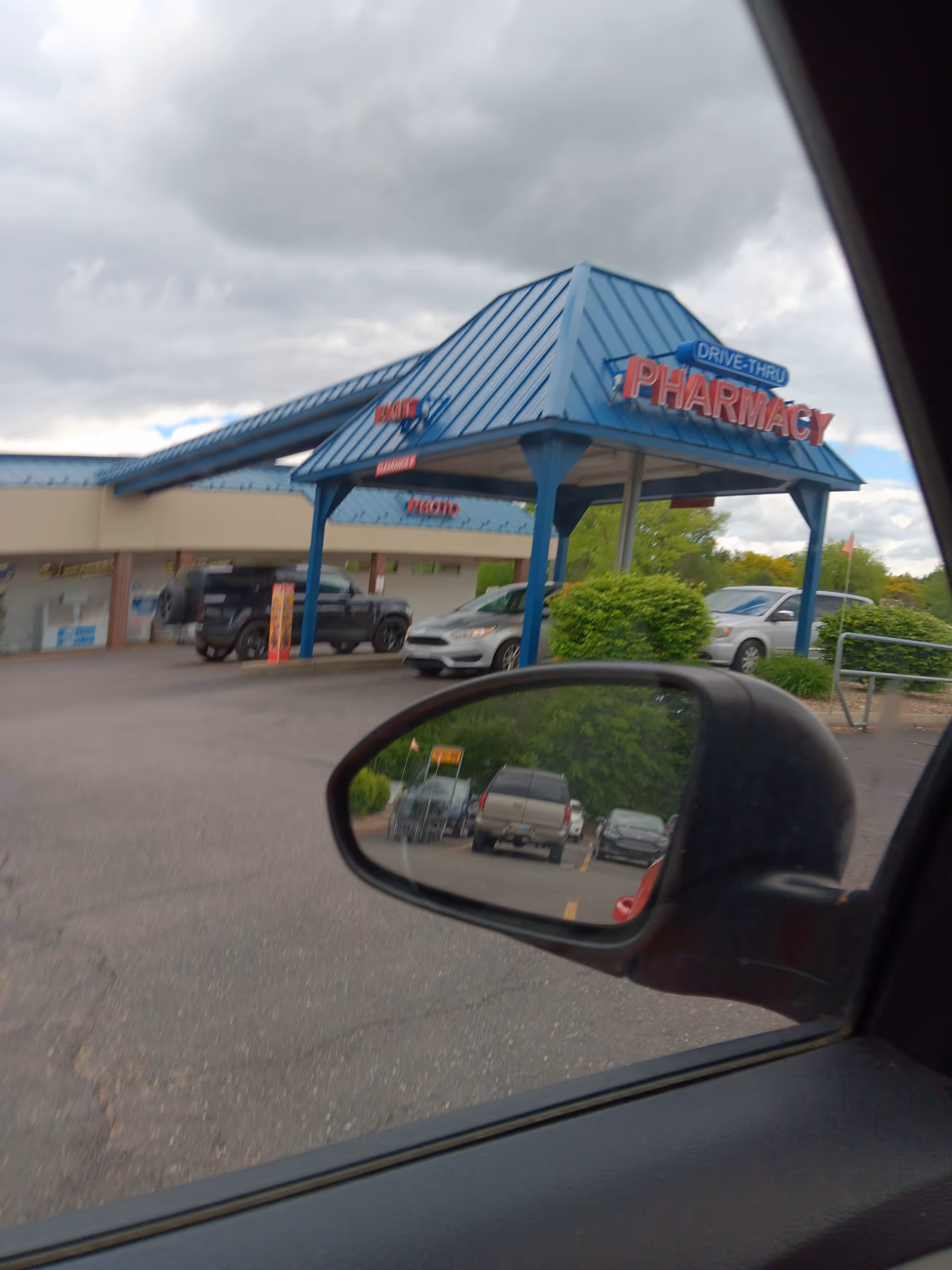 View of a Discount Drug Mart exterior with blue front canopy and drive-thru pharmacy.