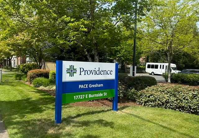 Providence Elderplace sign on a grassy lawn with trees and a white van in the background.