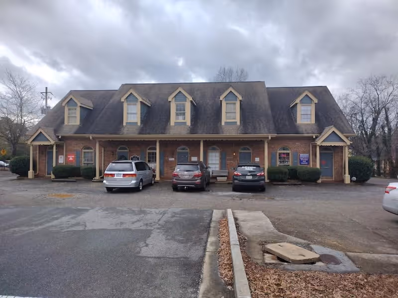 Brick building with dormer windows and parked cars in front of Mabry Medical Services LLC.