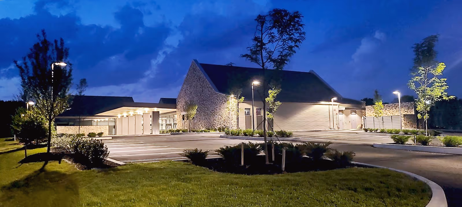 Front exterior view of Restore Orthopaedic Surgical Institute at night with parking and landscaping.