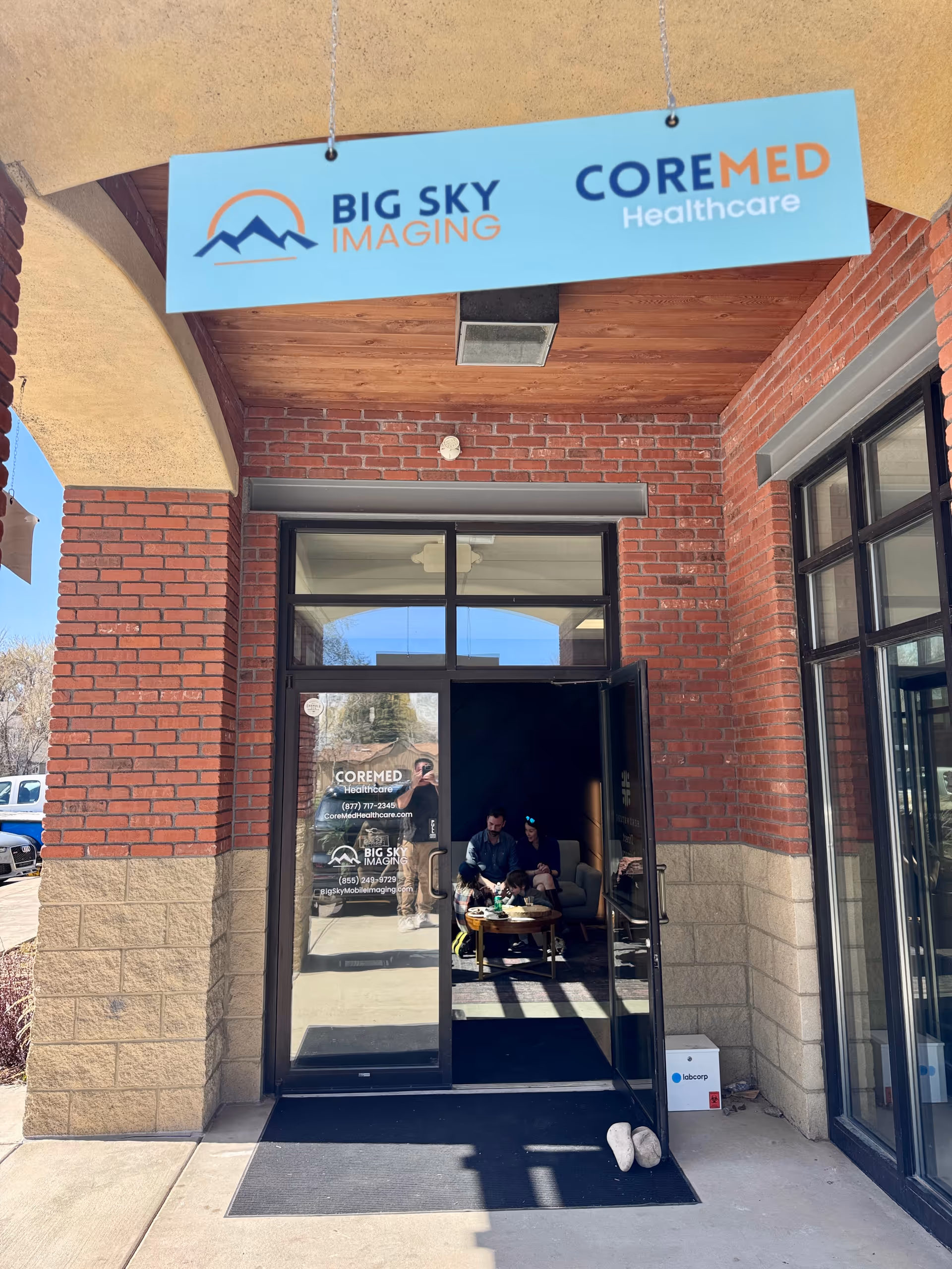 Open entrance to CoreMed Healthcare with people seated in a lobby area.