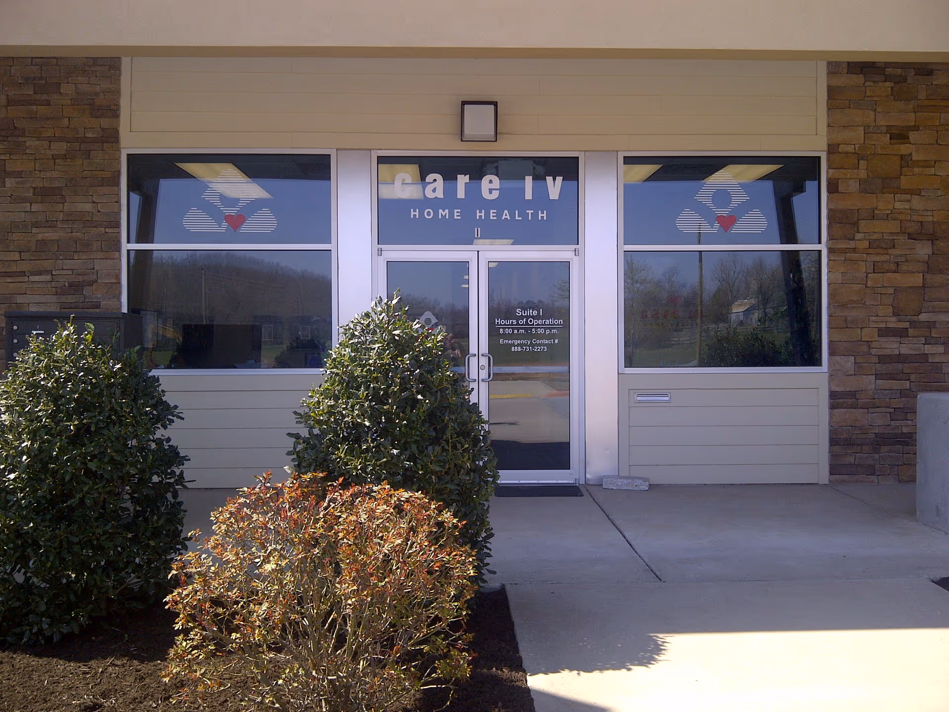 Exterior entrance of Care IV Home Health building with glass doors and stone facade