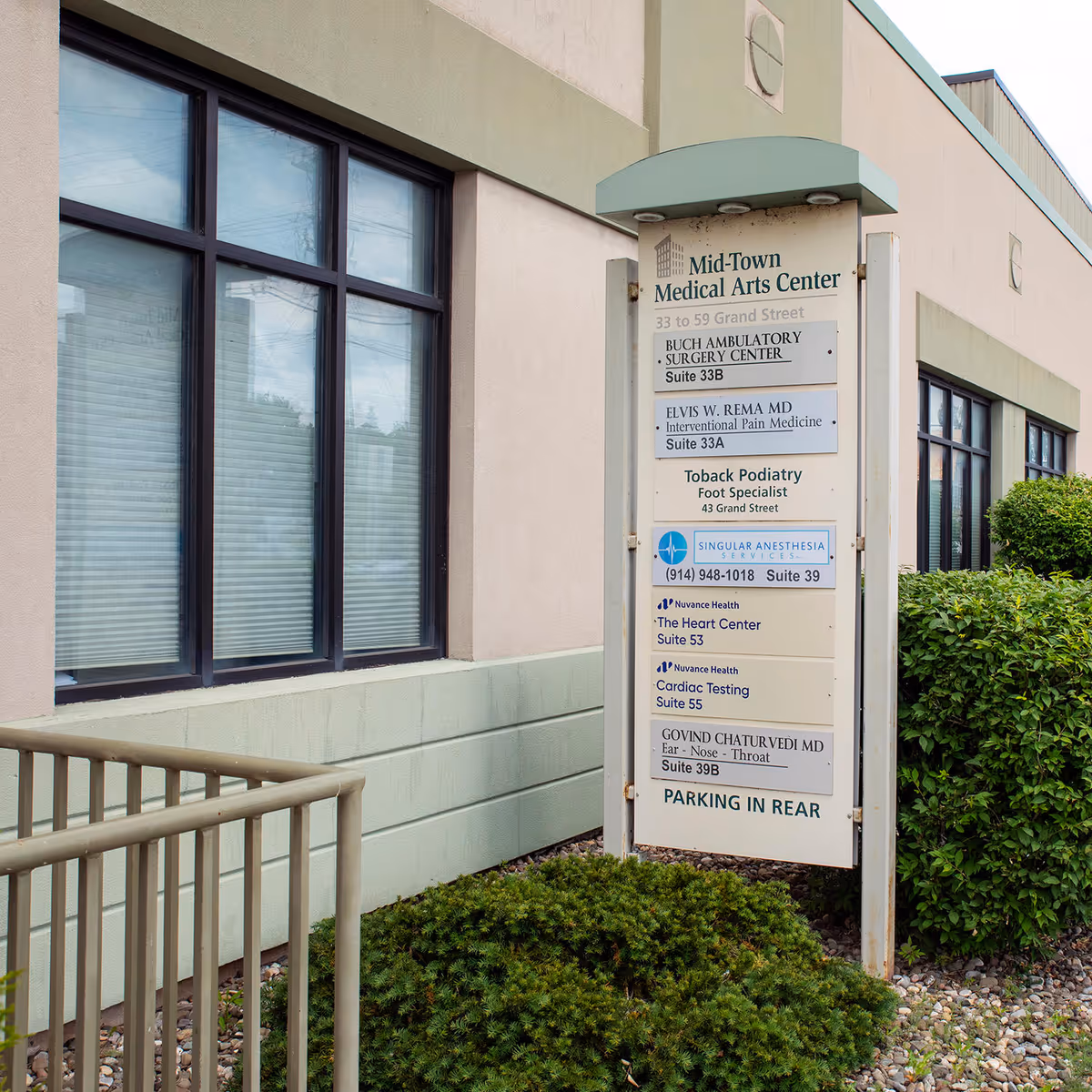 Exterior of a medical center with a tall directory sign and large windows.