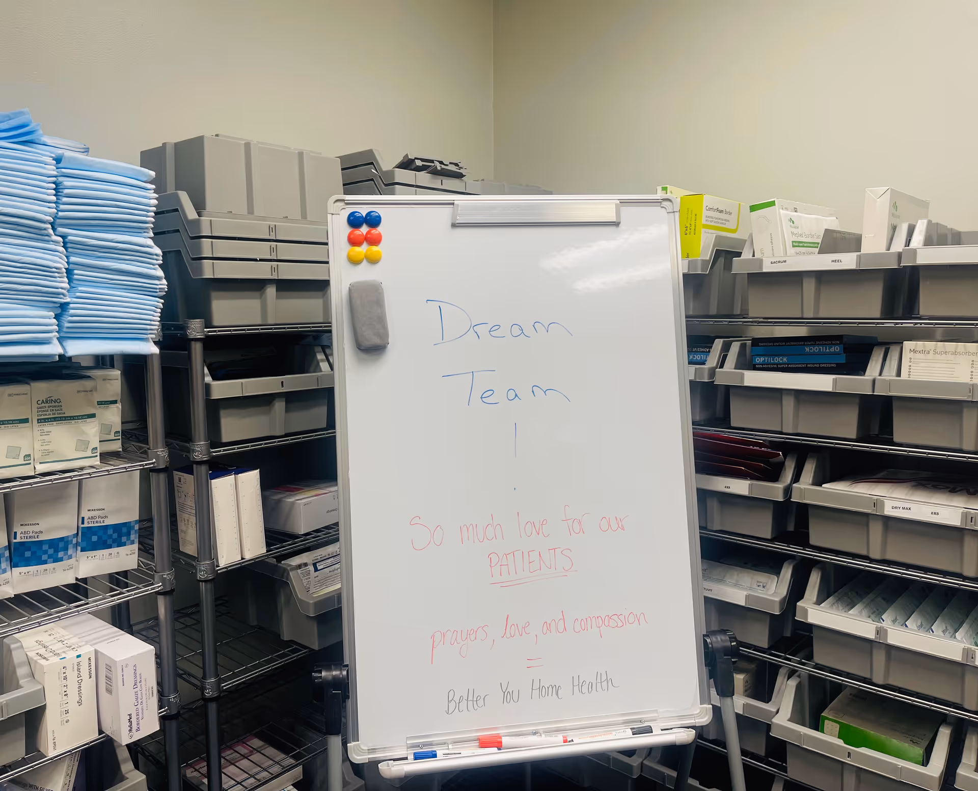 Whiteboard displays 'Dream Team' in a storage room surrounded by medical supply shelves.