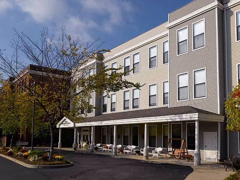 Atria Maplewood Place exterior featuring a covered entrance and front seating area