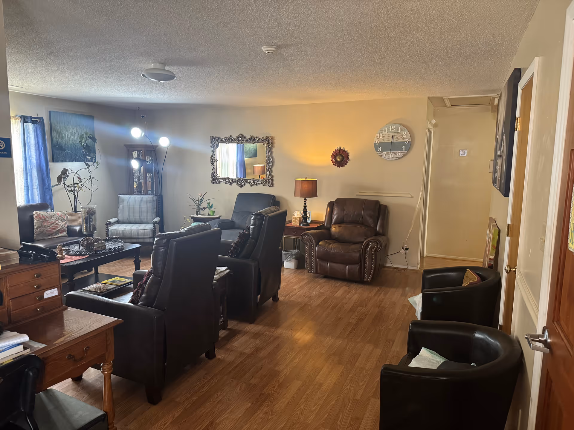 Cozy living room lounge with leather chairs, sofas, tables and warm lighting.