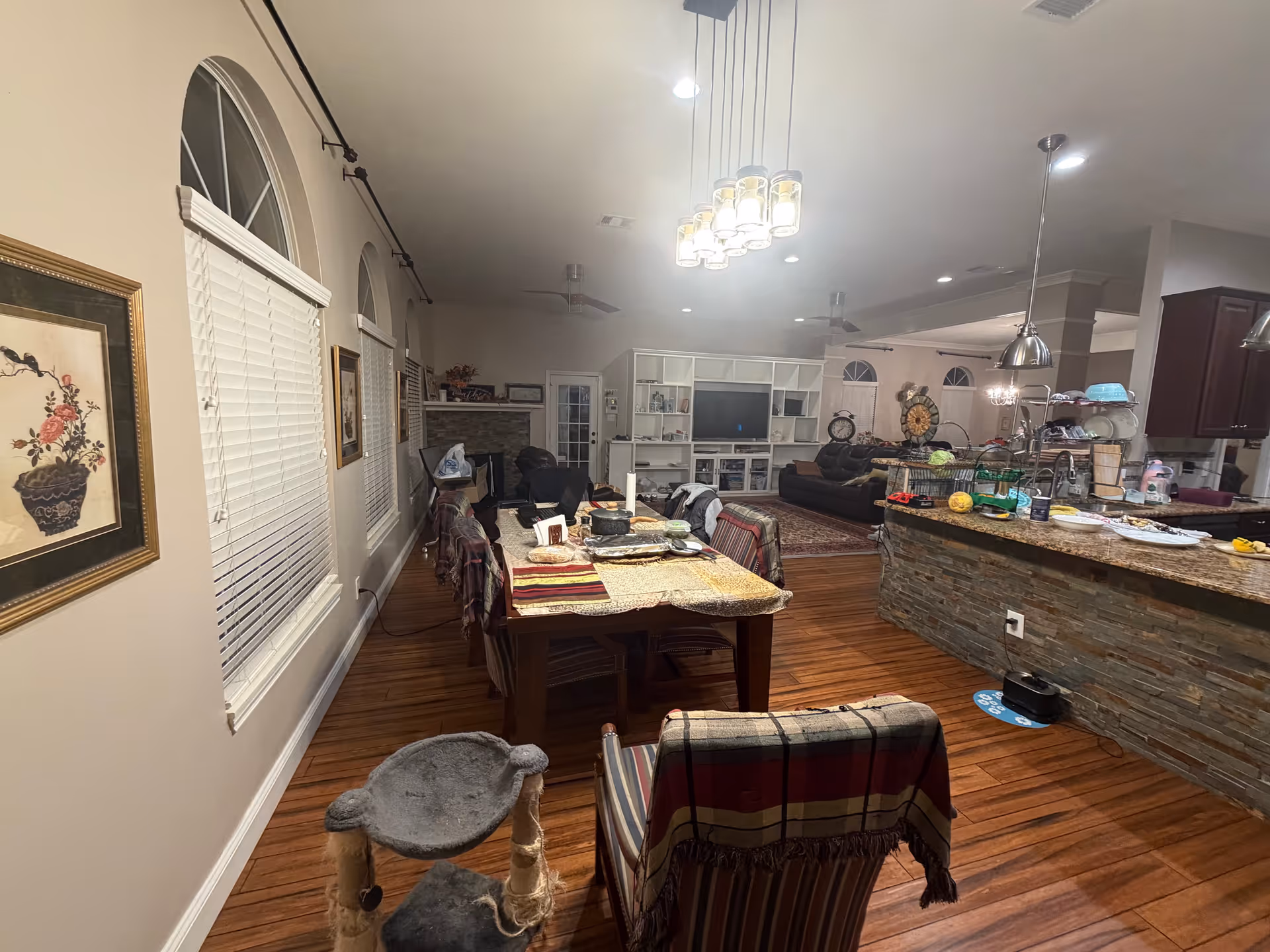 Open-concept living and dining area with a long table, island, and built-in shelving.