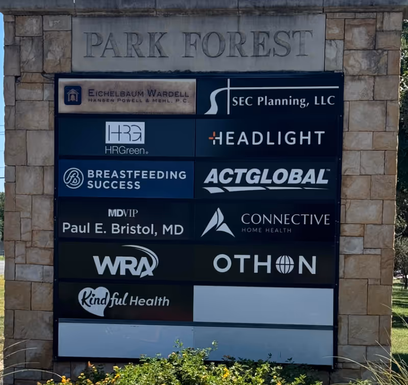 Stone signboard with Park Forest and multiple logos displayed
