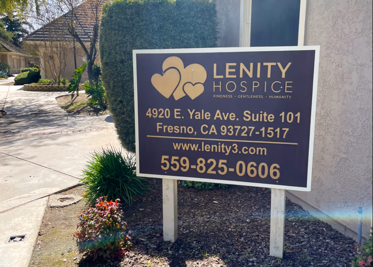 A large Lenity Hospice sign mounted on posts in front of a building.