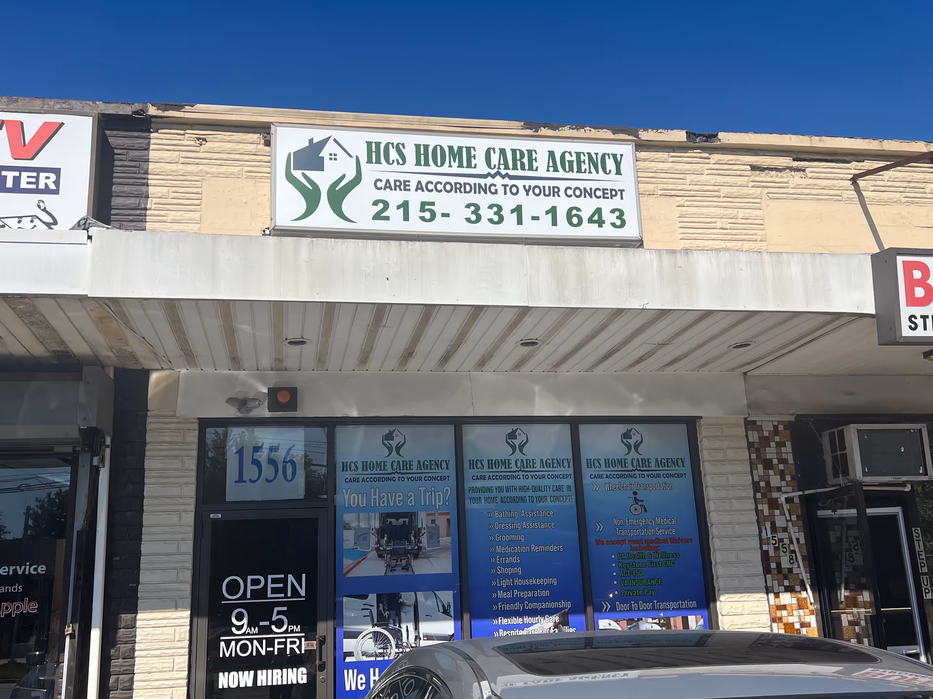 Exterior storefront with HCS Home Care Agency signage and blue posters.