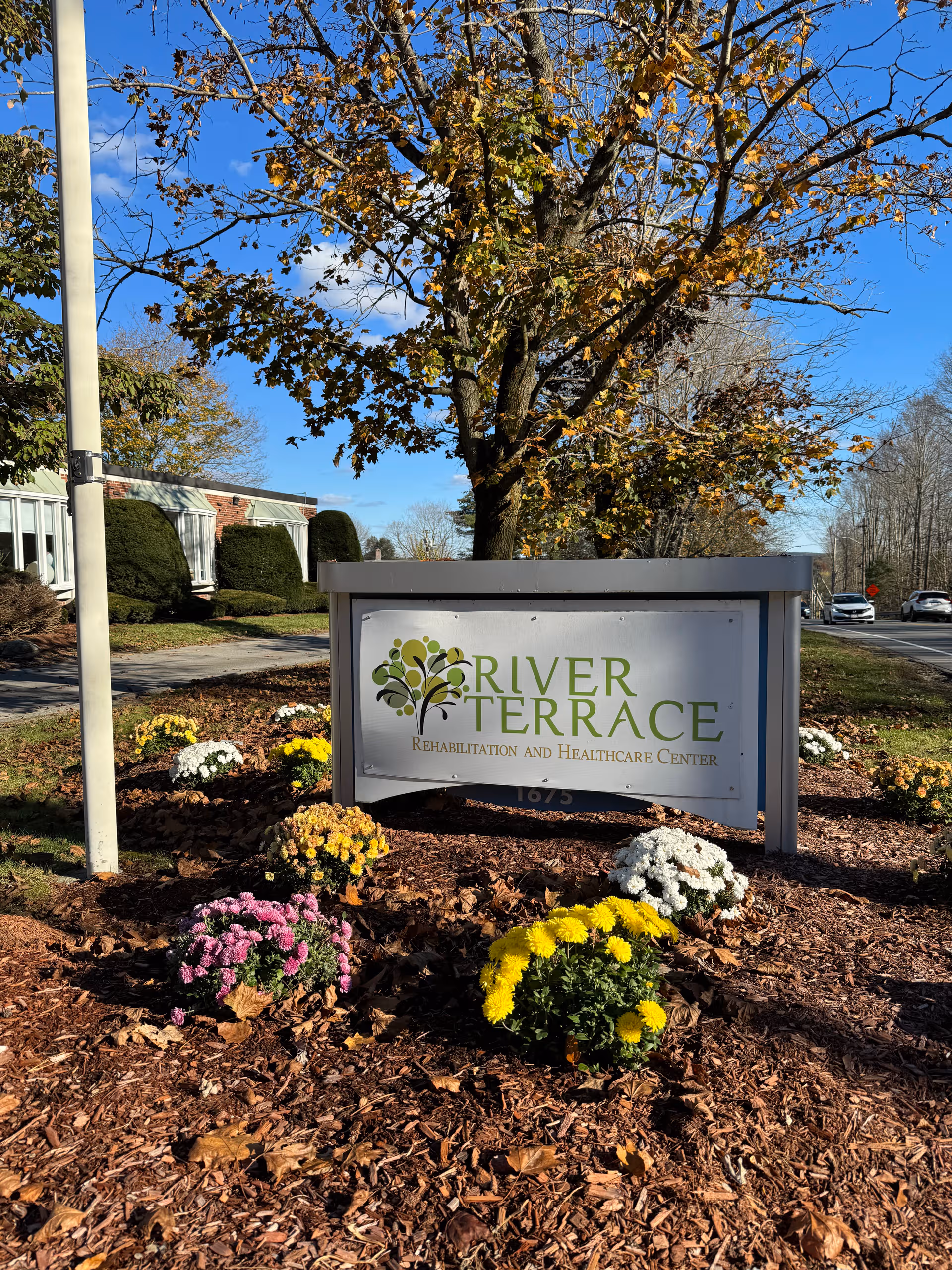 Exterior River Terrace Rehabilitation and Healthcare Center sign with colorful flowers.