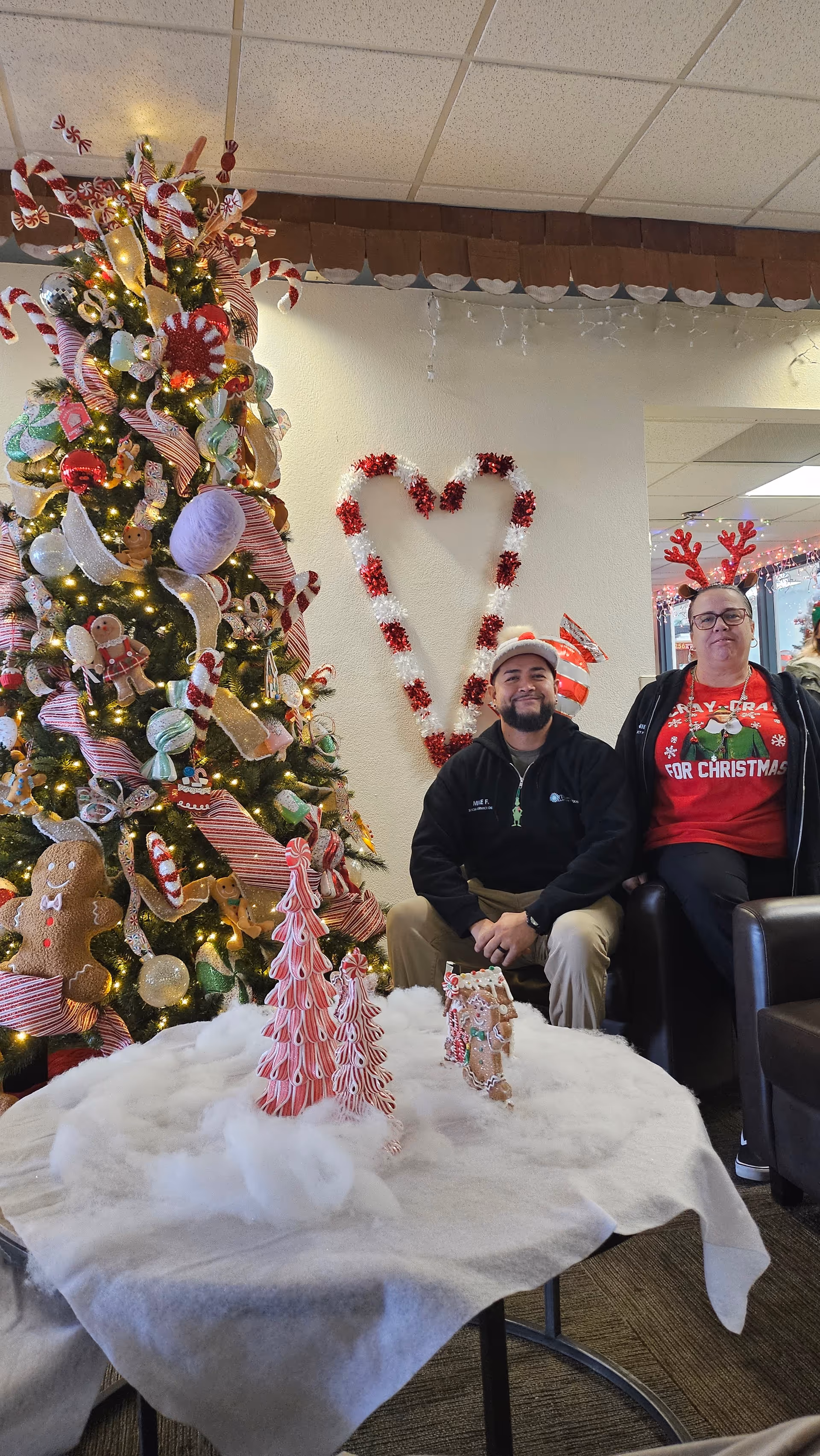 Festive indoor lobby at North Las Vegas Care Center with Christmas tree and two seated residents.