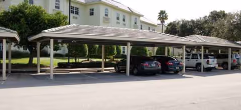 Exterior view of Brookdale Jensen Beach with covered parking and a two-story building.