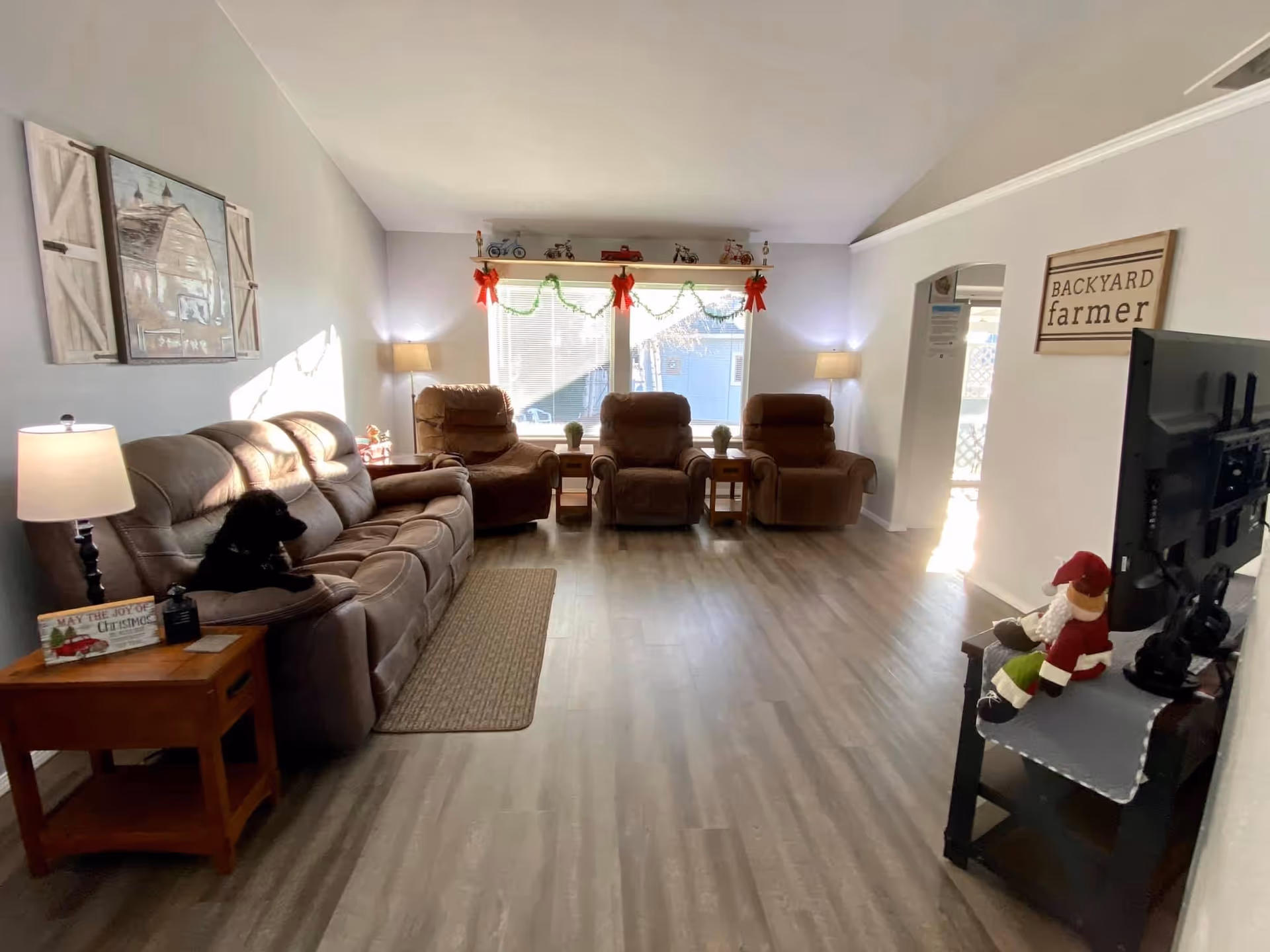 Parkway Adult Family Homecare common living room with leather seating, lamps, garlands, and a TV.