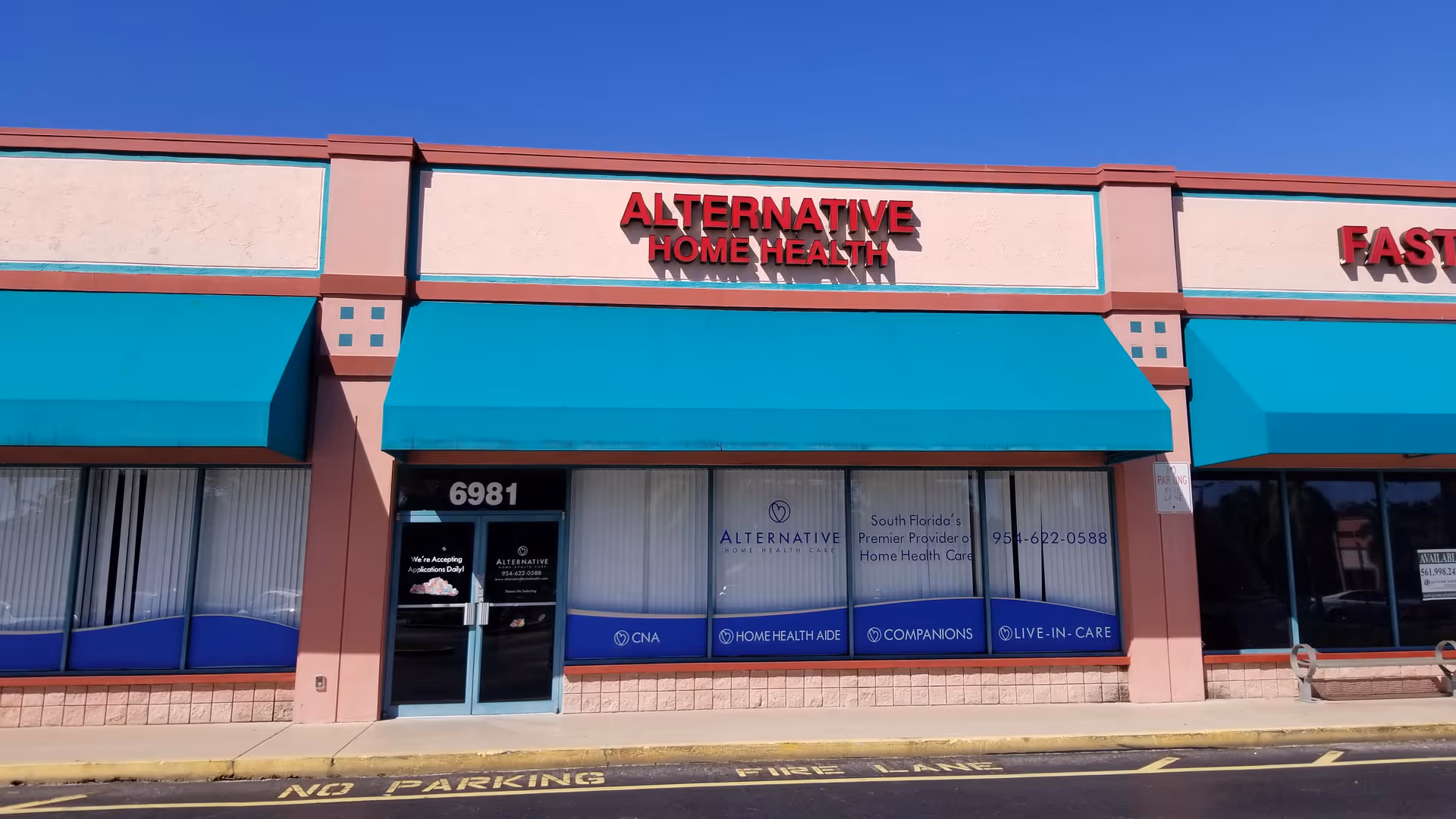 Exterior view of Alternative Home Health storefront with teal awnings and blue signage.