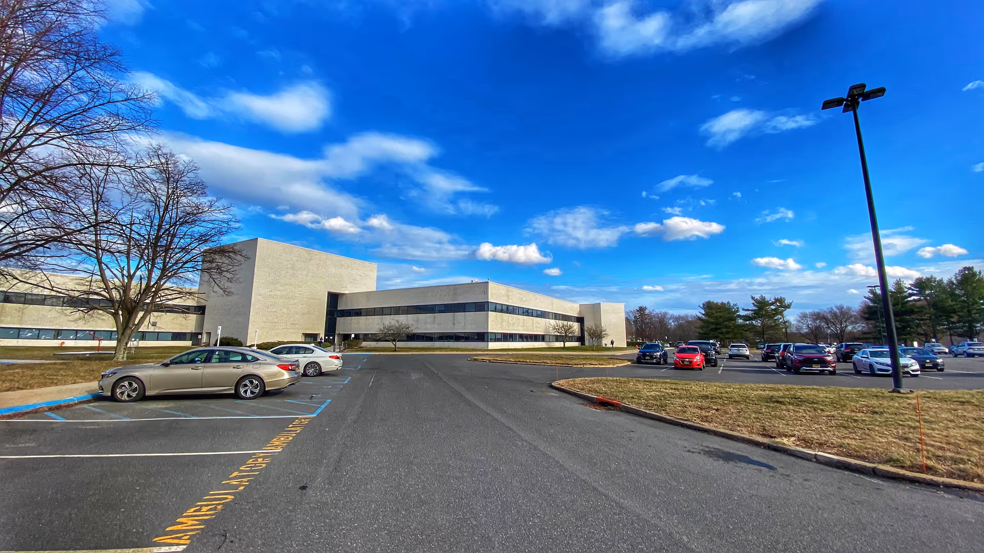 Visiting Nurse Association Health Group building with a parking lot and blue sky.