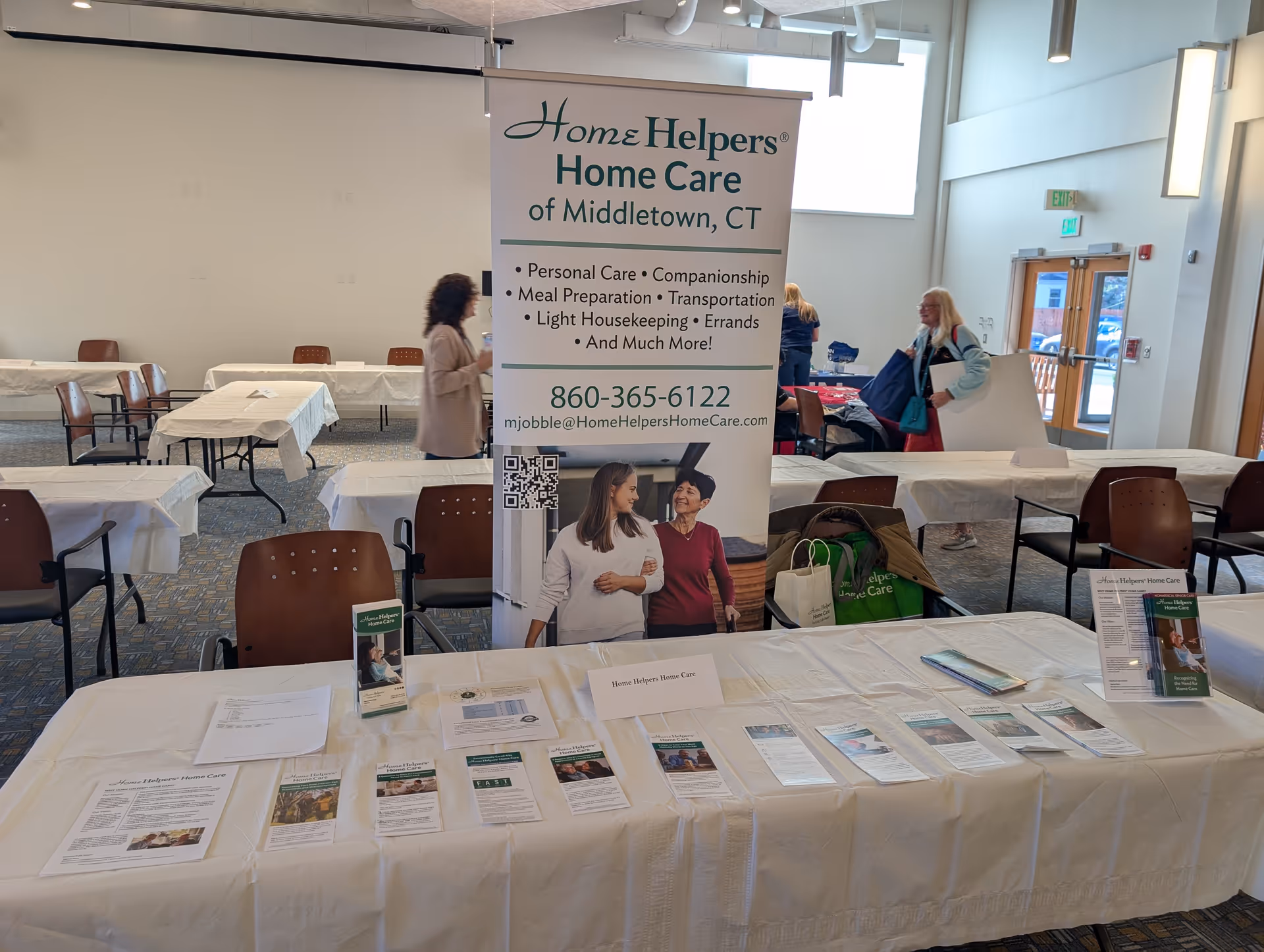 Indoor conference setup with a large banner for Home Helpers Home Care of Middletown.