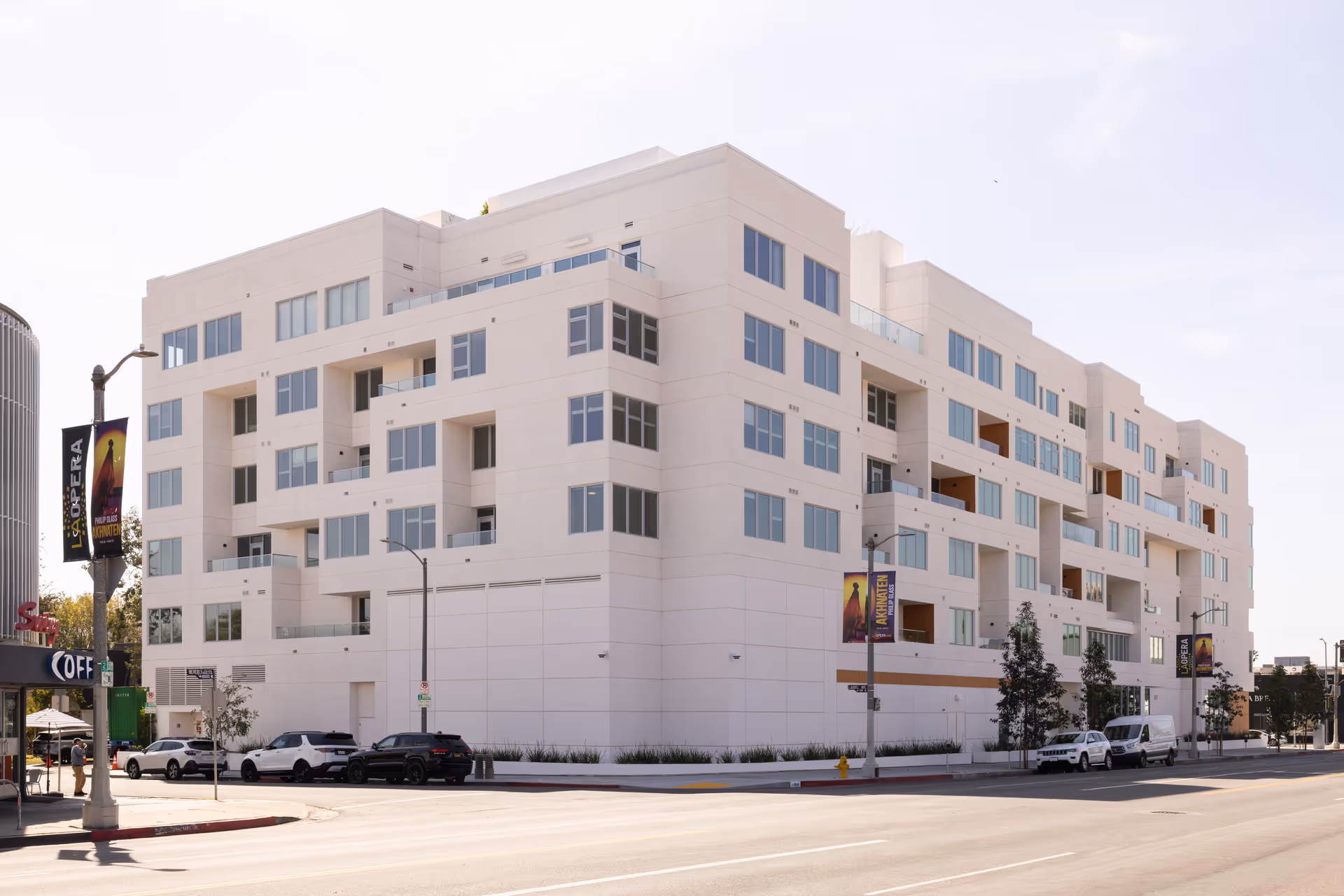 Front exterior view of The Leonard on Beverly, a white multi-story senior living building with balconies.