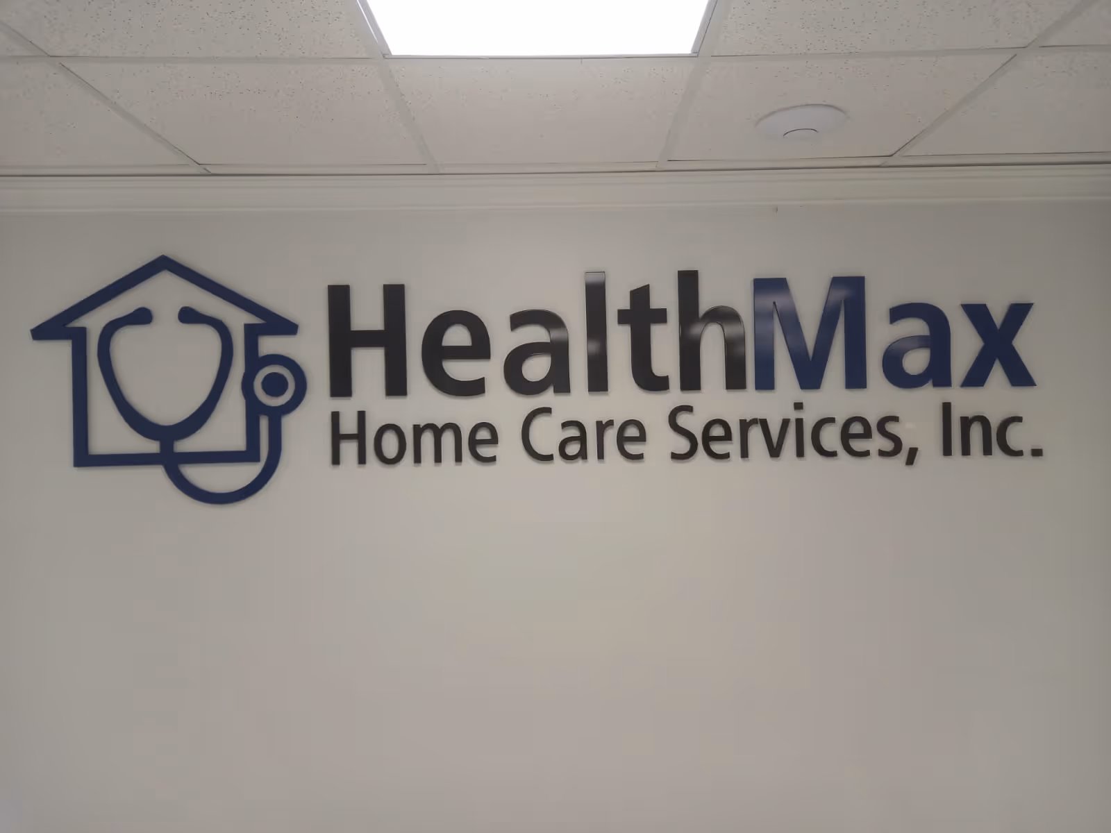 Interior wall sign displaying HealthMax Home Care Services, Inc. logo and name.