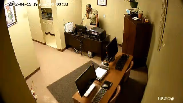 Reception area with a staff member at a desk and computers.