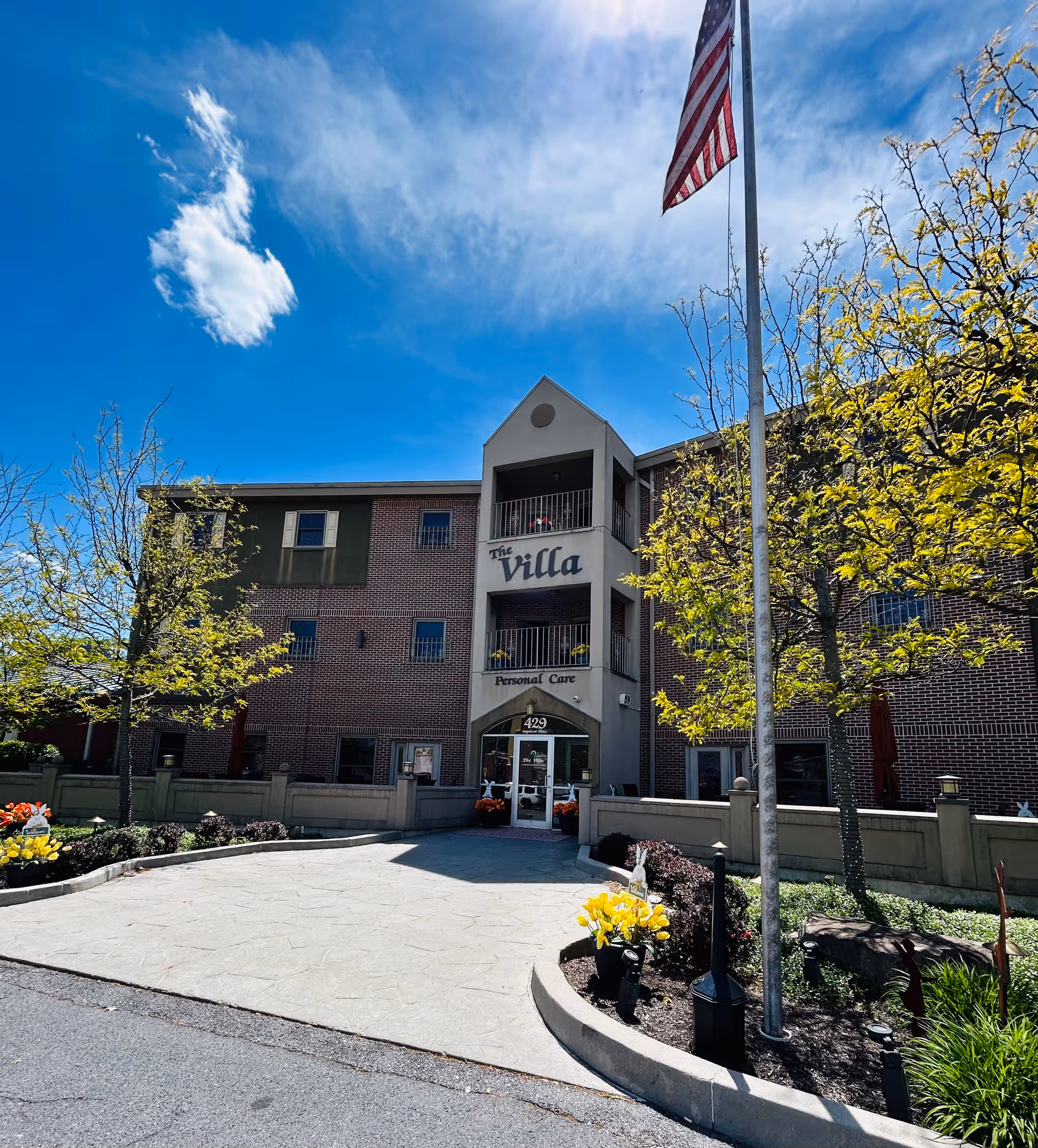 Exterior view of Villa Assisted Living LLC building with entrance and flagpole