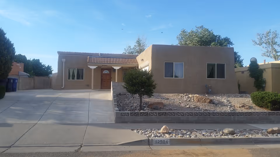 Front view of Singing Arrow Manor, a single-story beige stucco senior facility.