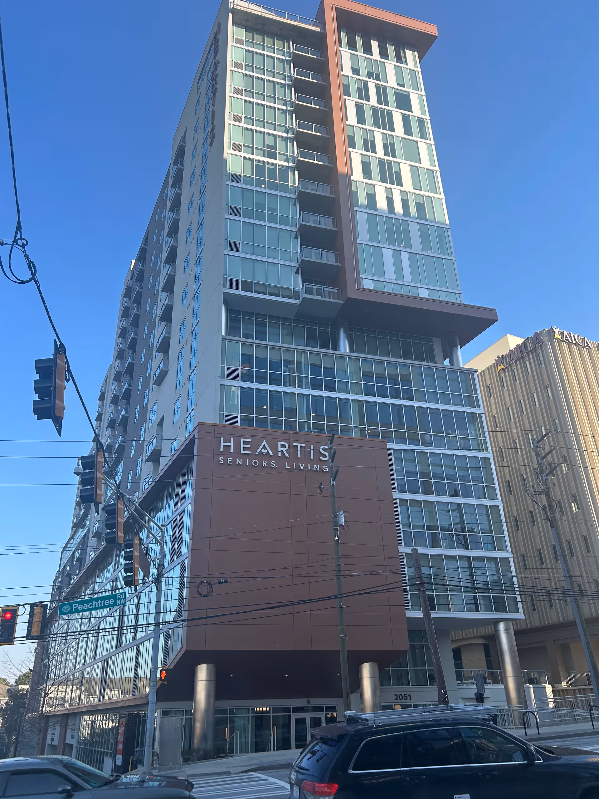 Tall glass-fronted building with Heartis Seniors Living signage along Buckhead street