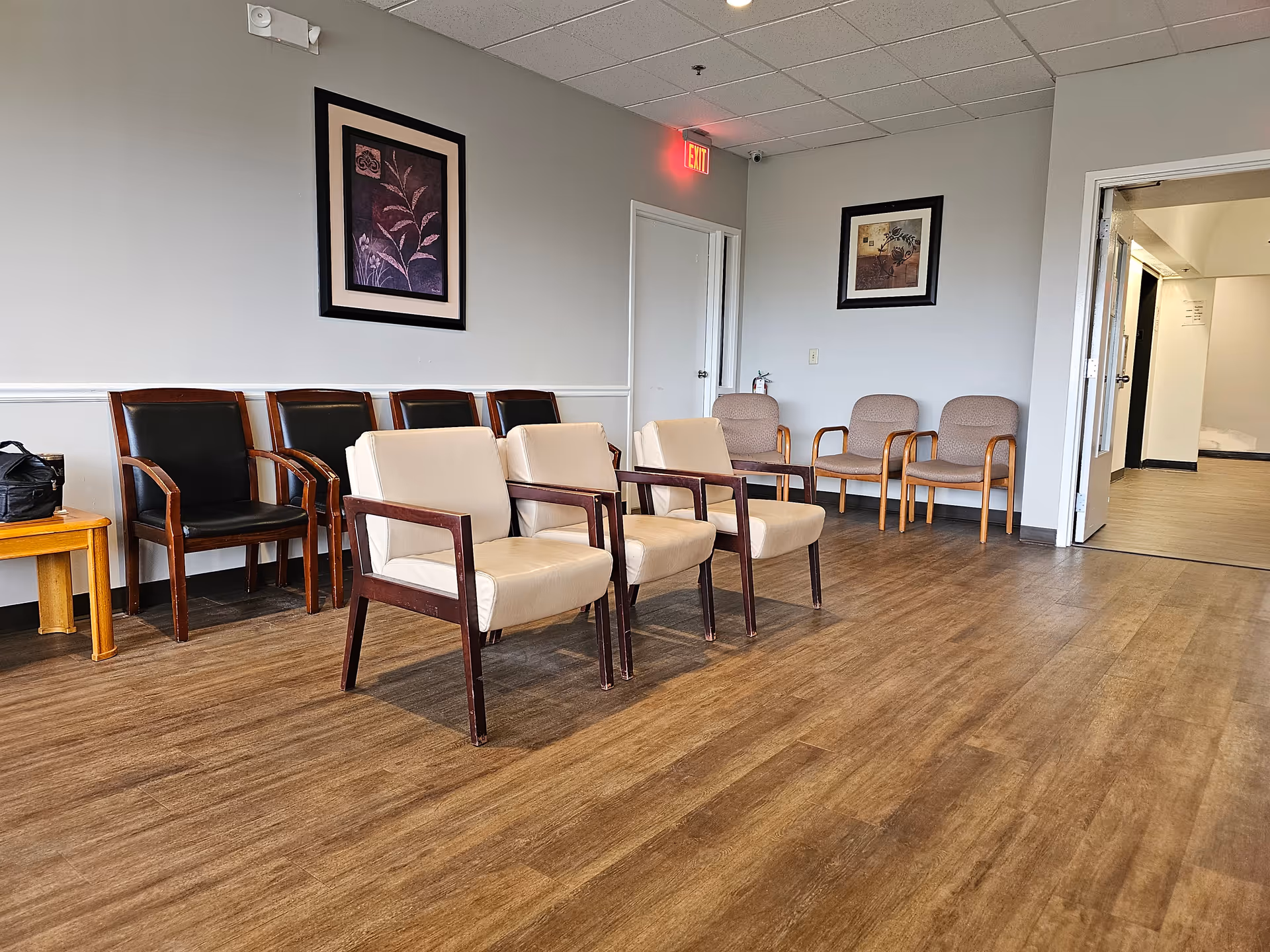 A calm interior waiting area with multiple chairs and a doorway.