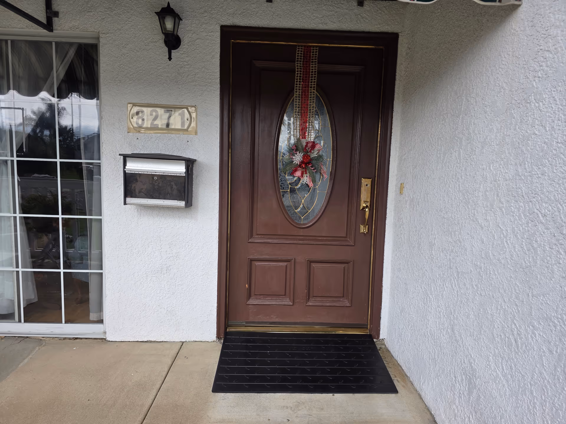 Front entrance of a senior living facility with a decorated brown door.