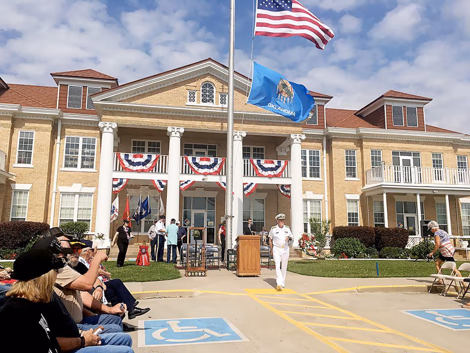 Front of State of Oklahoma Department of Veterans Affairs building with flags and ceremony.