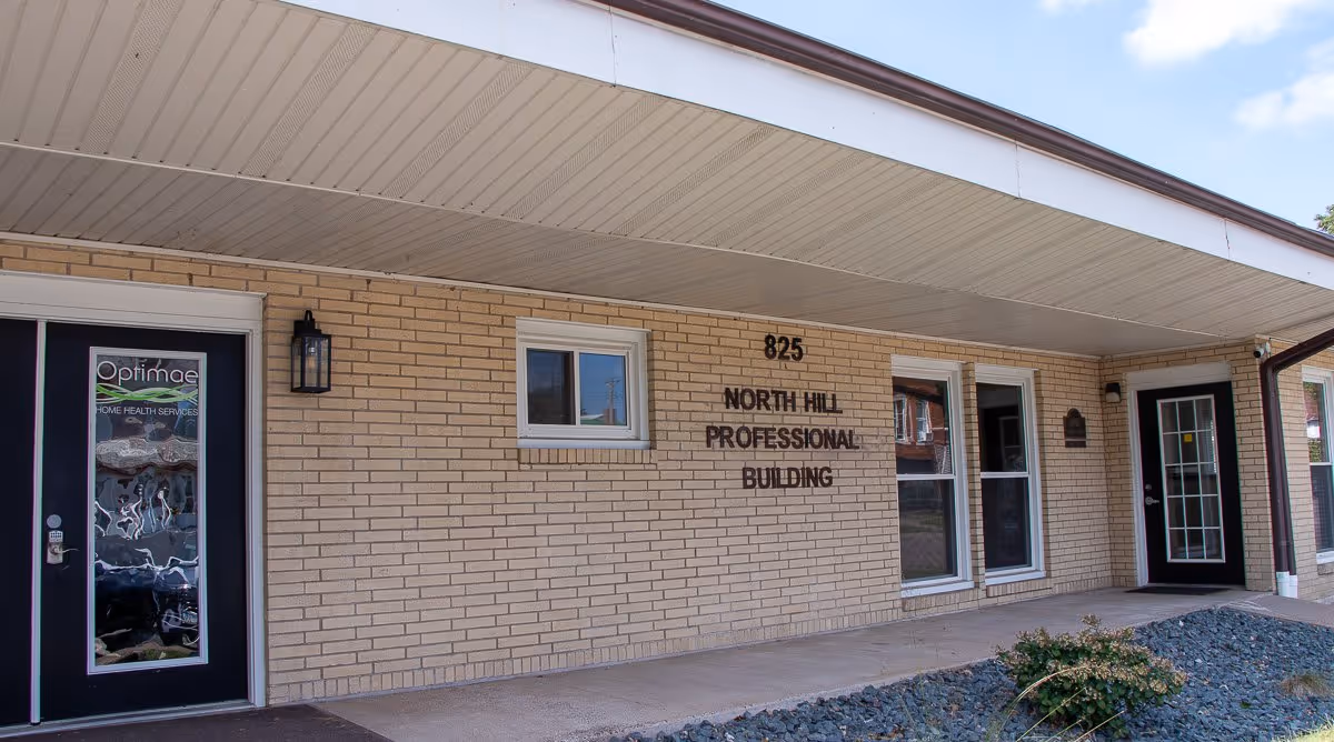Brick exterior of Optimae Home Health Services building with entrance and signage.