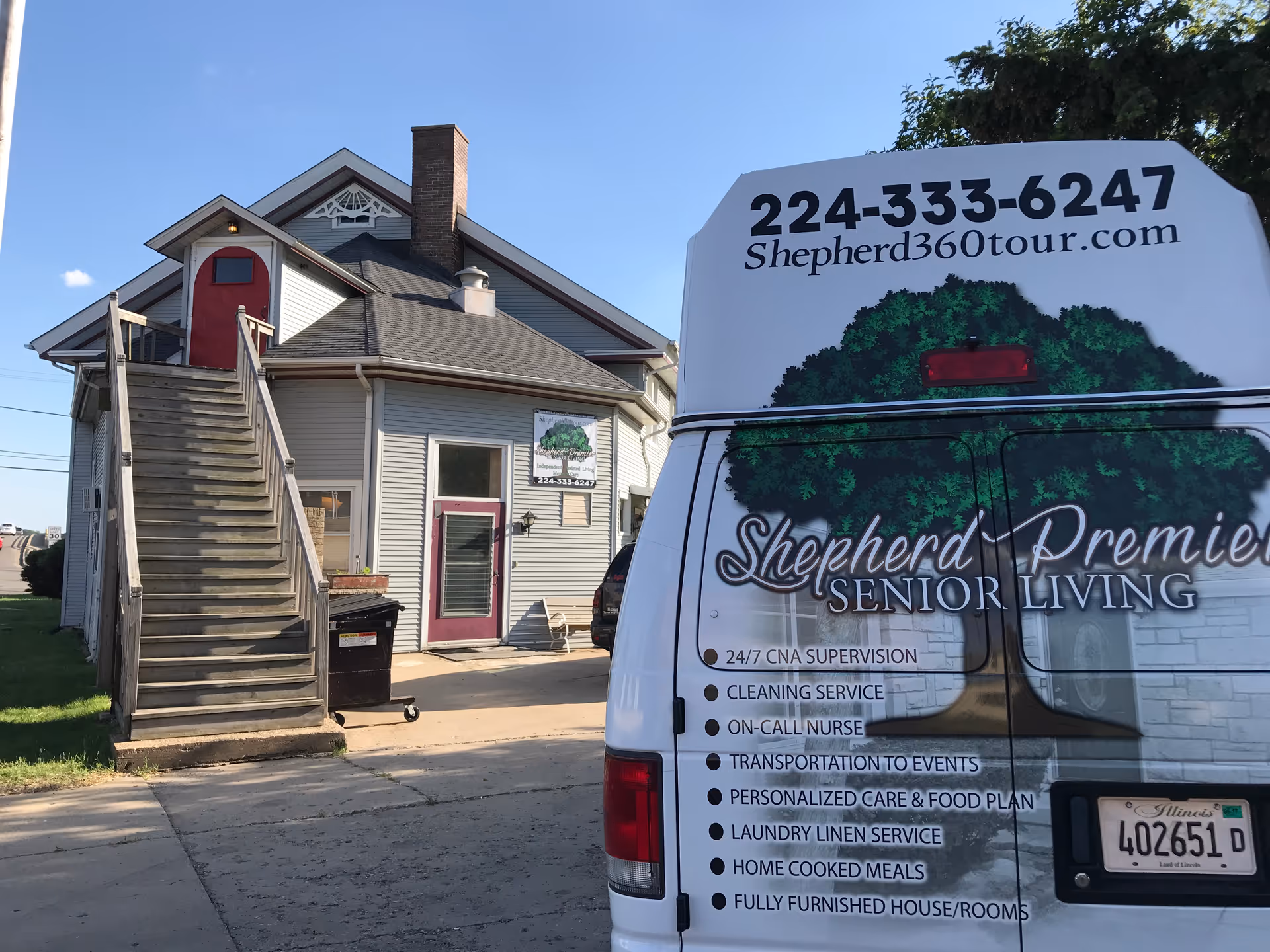 Exterior view of a building with stairs and a branded senior living van nearby