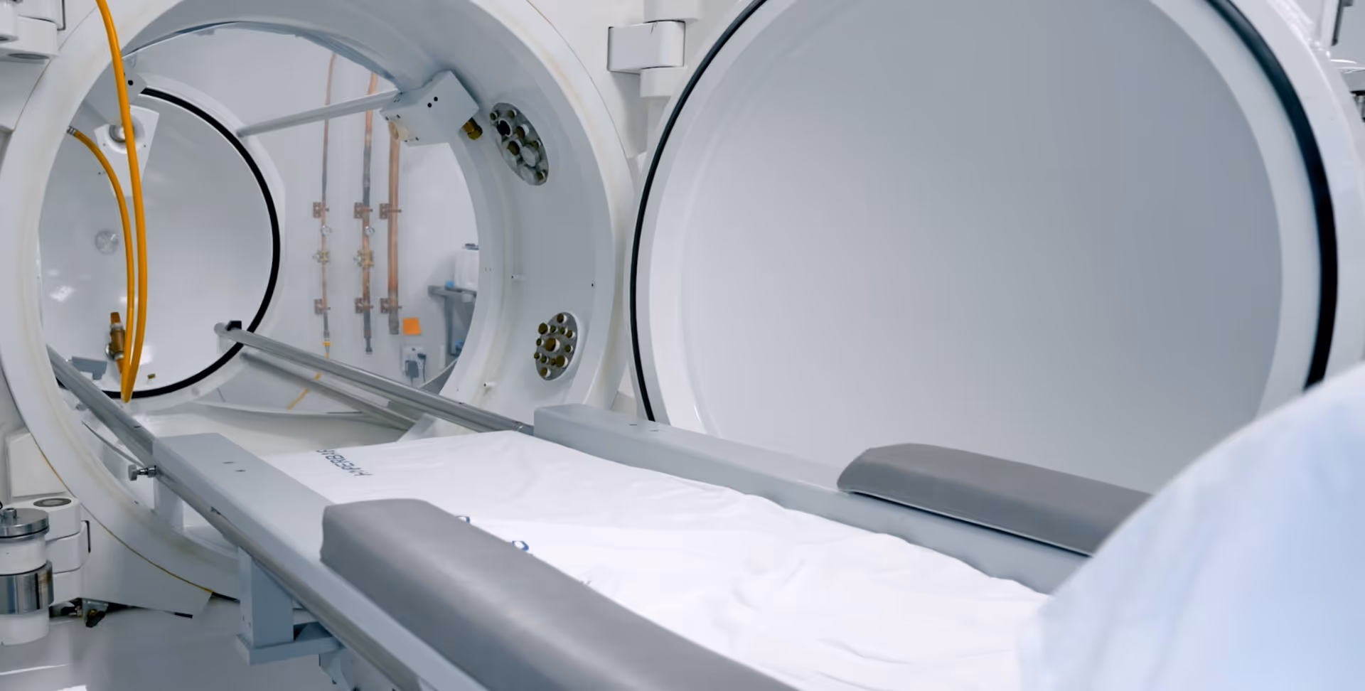 Imaging suite with a large circular scanner and a patient table ready for imaging.