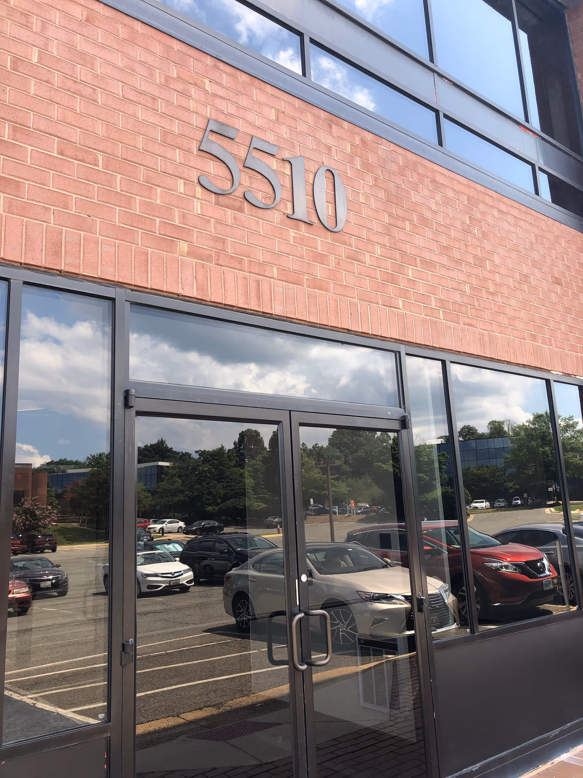 Brick-front Sunshine Home Healthcare building with glass entry doors and a parking lot.