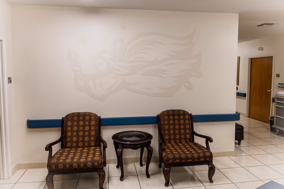 Lobby seating area with two patterned chairs and a small round table.