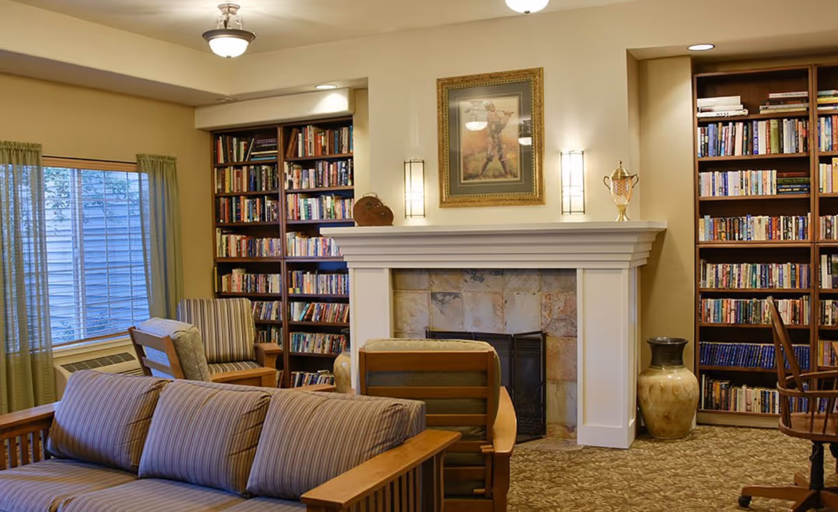 Cozy living room with fireplace, bookshelves, and comfortable seating.