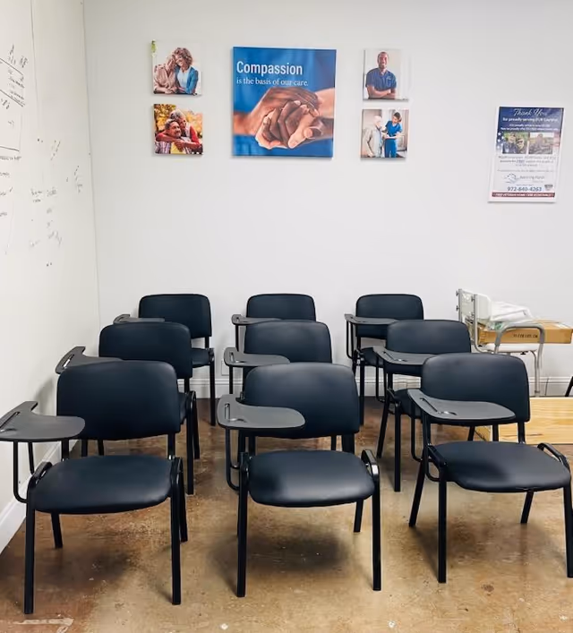 Empty classroom-style room with black chairs arranged in rows and wall posters.