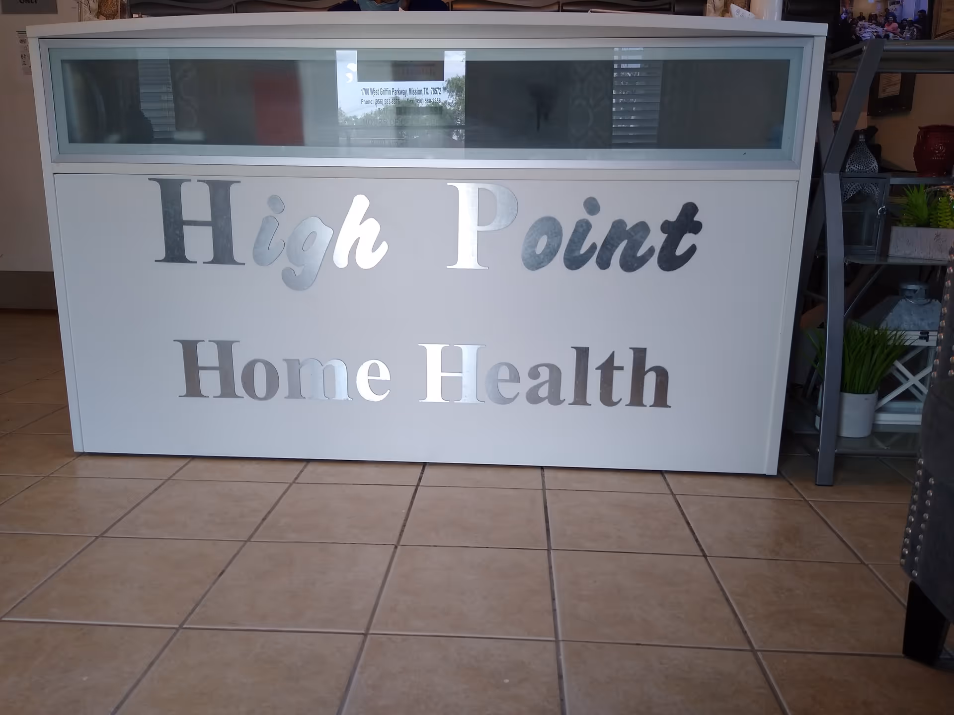 A reception desk with High Point Home Health signage in a tiled lobby.