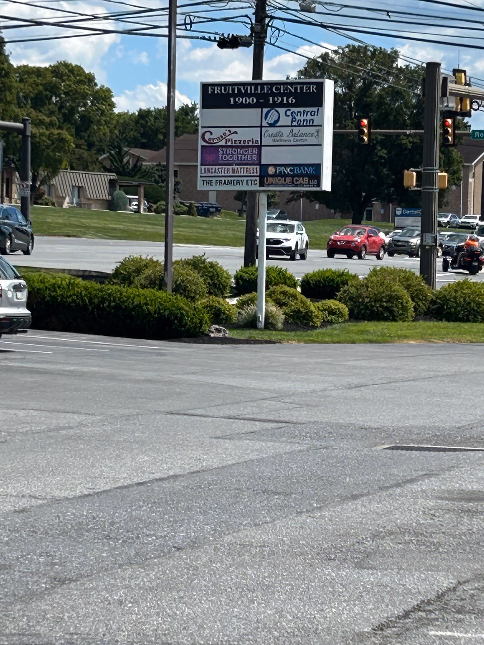 Outdoor street view with a large signboard and traffic near Central Penn Nursing Care.