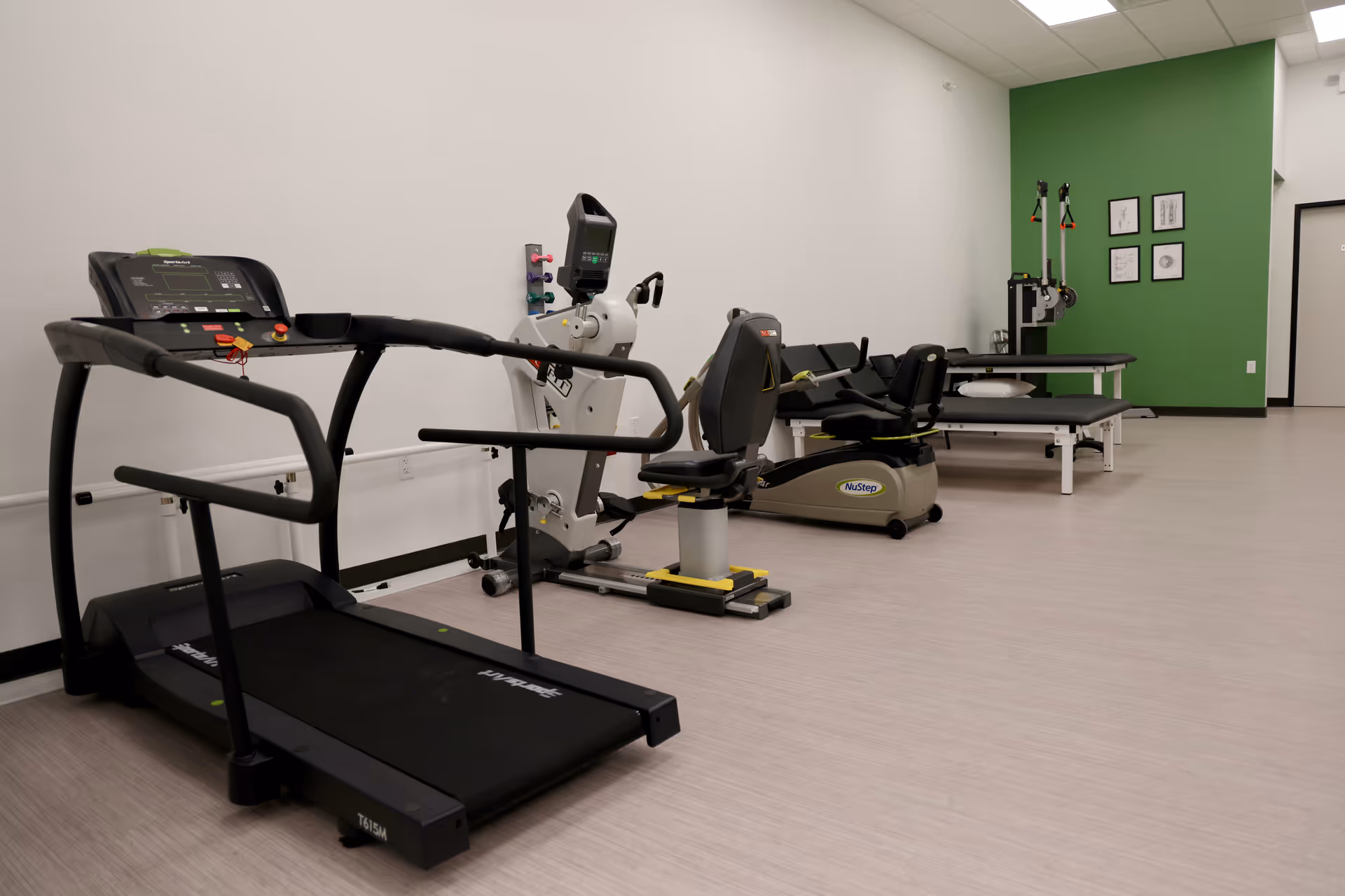 A rehab gym room with treadmills and therapy equipment in a bright facility
